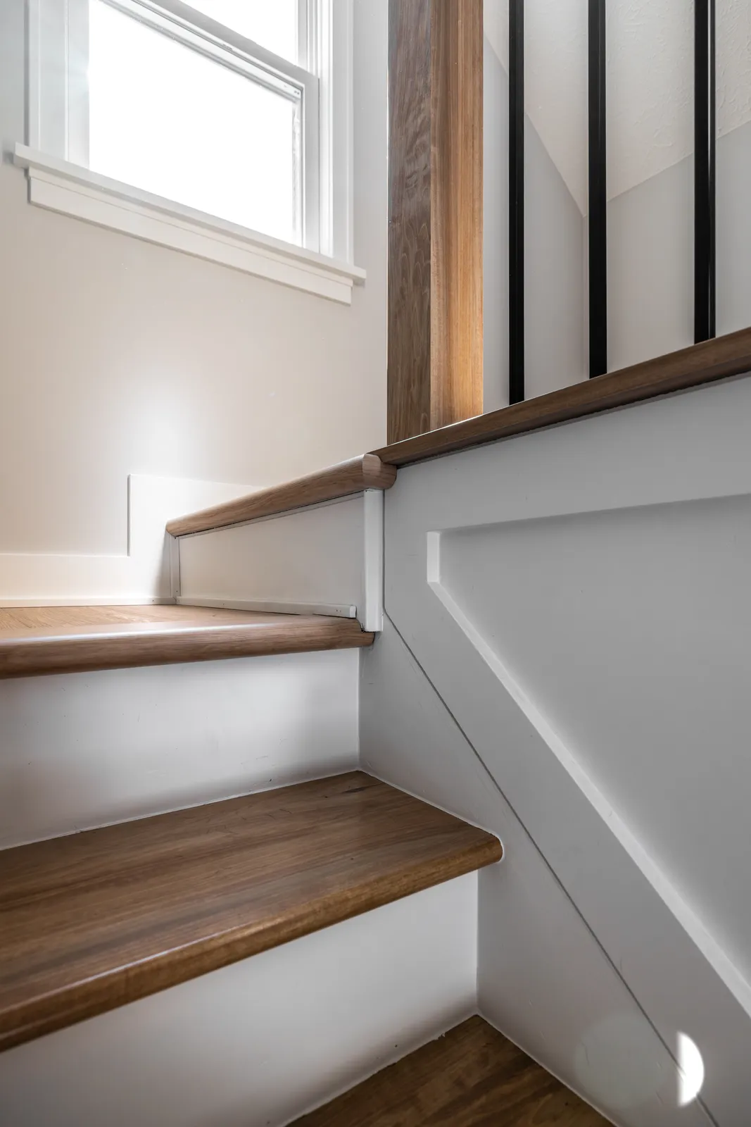 Stair landing with wainscoting and walnut newel post